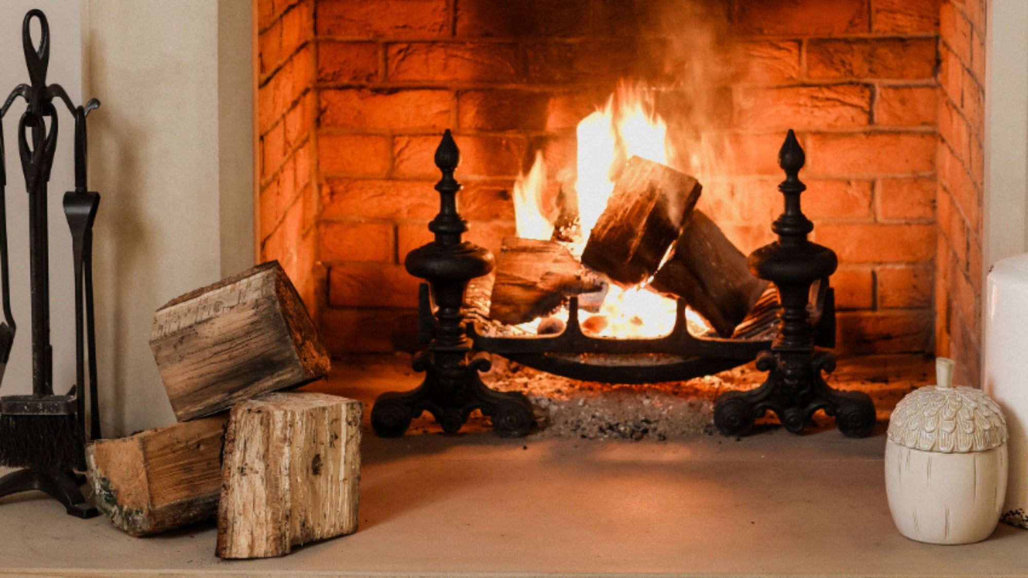 Fireplace accessories by a lit fire.