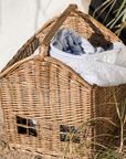 Woven basket with handle with striped throw stored inside.