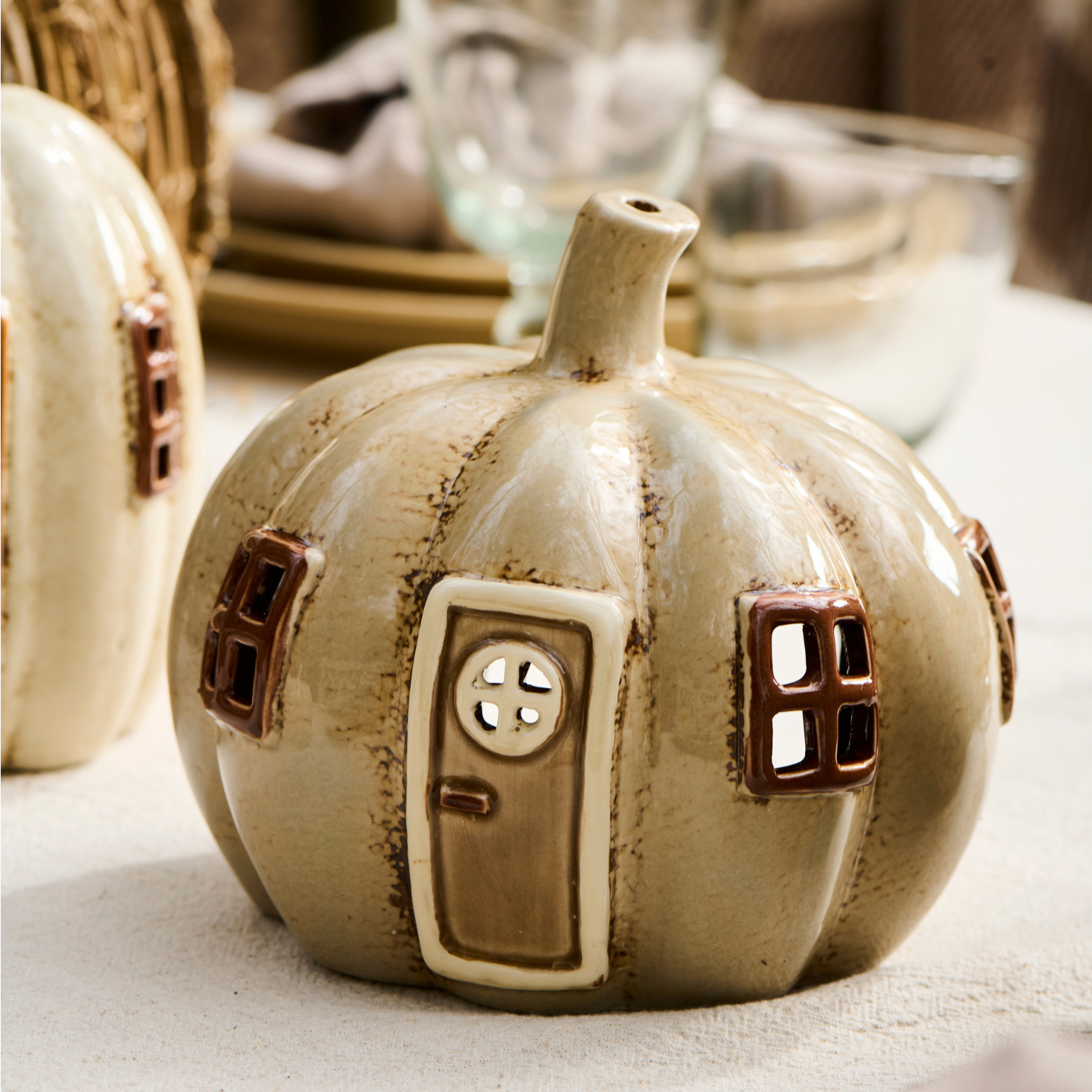 Ceramic pumpkin shaped tea light holder on table.