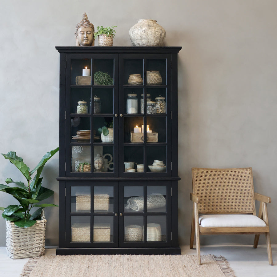 Black armoire cabinet displaying home decor.