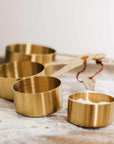 Measuring Cups filled with sugar on a floured surface.