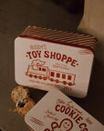 Set of two Christmas themed red and white candy cane storage tins on stone fireplace with a mince pie.