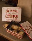 Set of two Christmas themed red and white candy cane storage tins on stone fireplace with a mince pie.