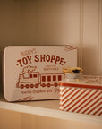 Set of two Christmas themed red and white candy cane storage tins on a white shelf with a mince pie.