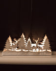 Aged White Reindeer Forest Christmas Holder on black panelled wall.