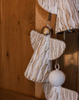 White and gold christmas angels hanging decoration on wooden door.