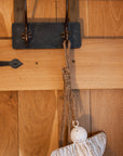 White and gold christmas angels hanging decoration on wooden door.