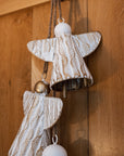 White and gold christmas angels hanging decoration on wooden door.