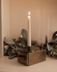 Antique Brass Candle Holder With Drawer and matches on white cabinet.