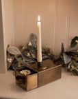 Antique Brass Candle Holder With Drawer and matches on white cabinet.