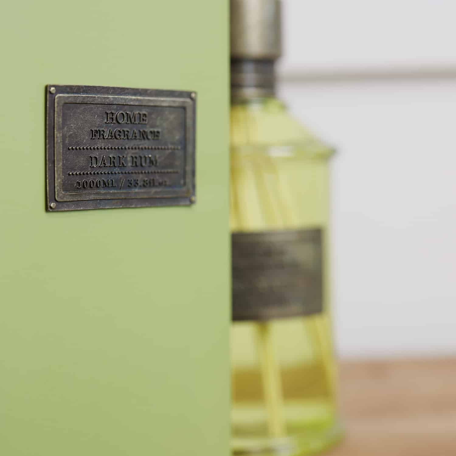 Home fragrance dark rum and lime green reed diffuser presentation box close up
