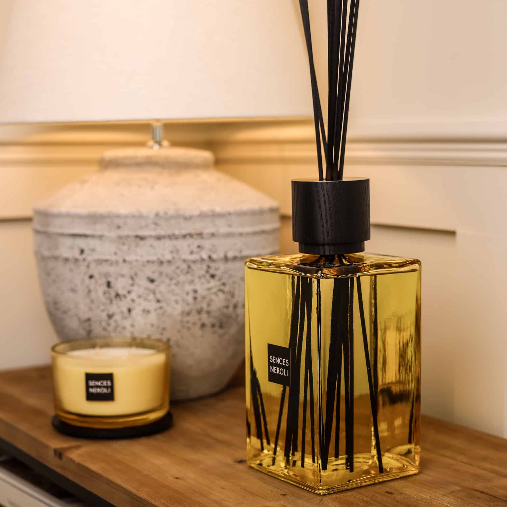 Sences Neroli Extra Large Reed Diffuser on wooden console table styled with lamp and candle.