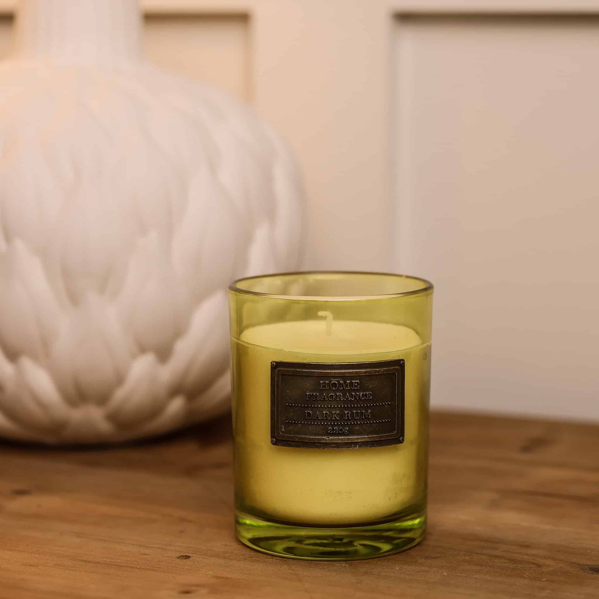 Dark Rum and Lime Candle on wooden console styled with white vase.