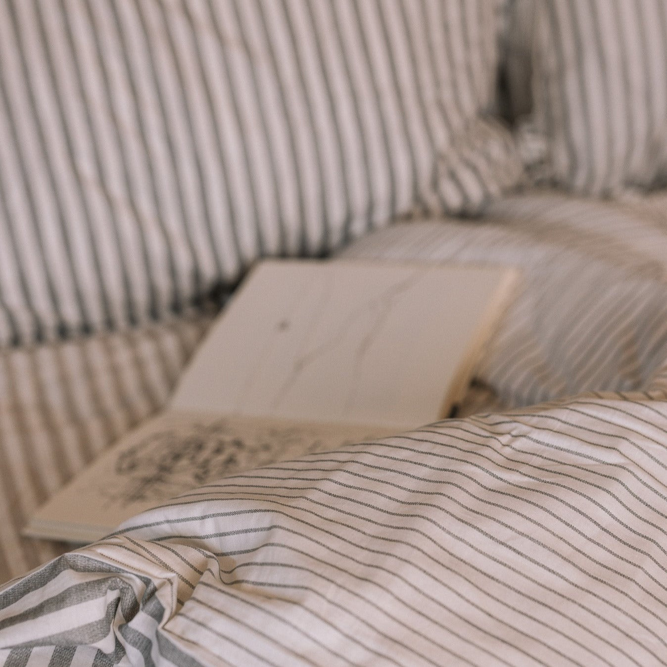 Grey Striped Bedding with an open book.