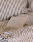 Grey Striped Bedding with an open book.