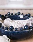 Blue ceramic bobble bowl with white napkins and artichokes. 