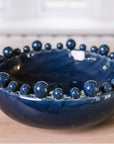 Blue ceramic bobble bowl on a wooden table.