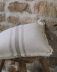 Grey and cream striped cushion on wooden stool.