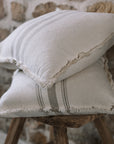 Grey and cream striped cushion on wooden stool.