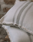 Grey and cream striped cushion on wooden stool.