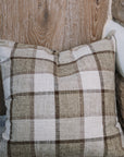 Brown and cream checkered cushion on wooden stool.