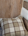 Brown and cream checkered cushion on wooden stool.