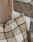 Brown and cream checkered cushion on wooden stool.