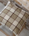 Brown and cream checkered cushion on wooden stool.