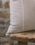 Beige and white striped cushion on a wooden stool.