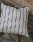 Olive and off white striped cushion on wooden stool.