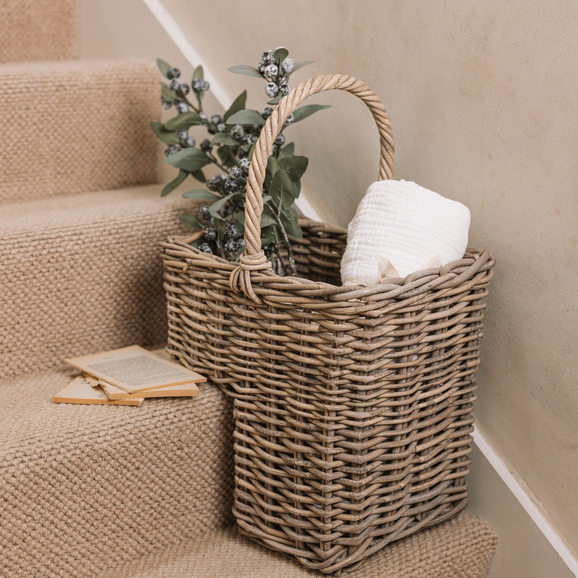 Wicker Stair Basket filled with flowers and a blanket.