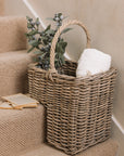 Wicker Stair Basket filled with flowers and a blanket.