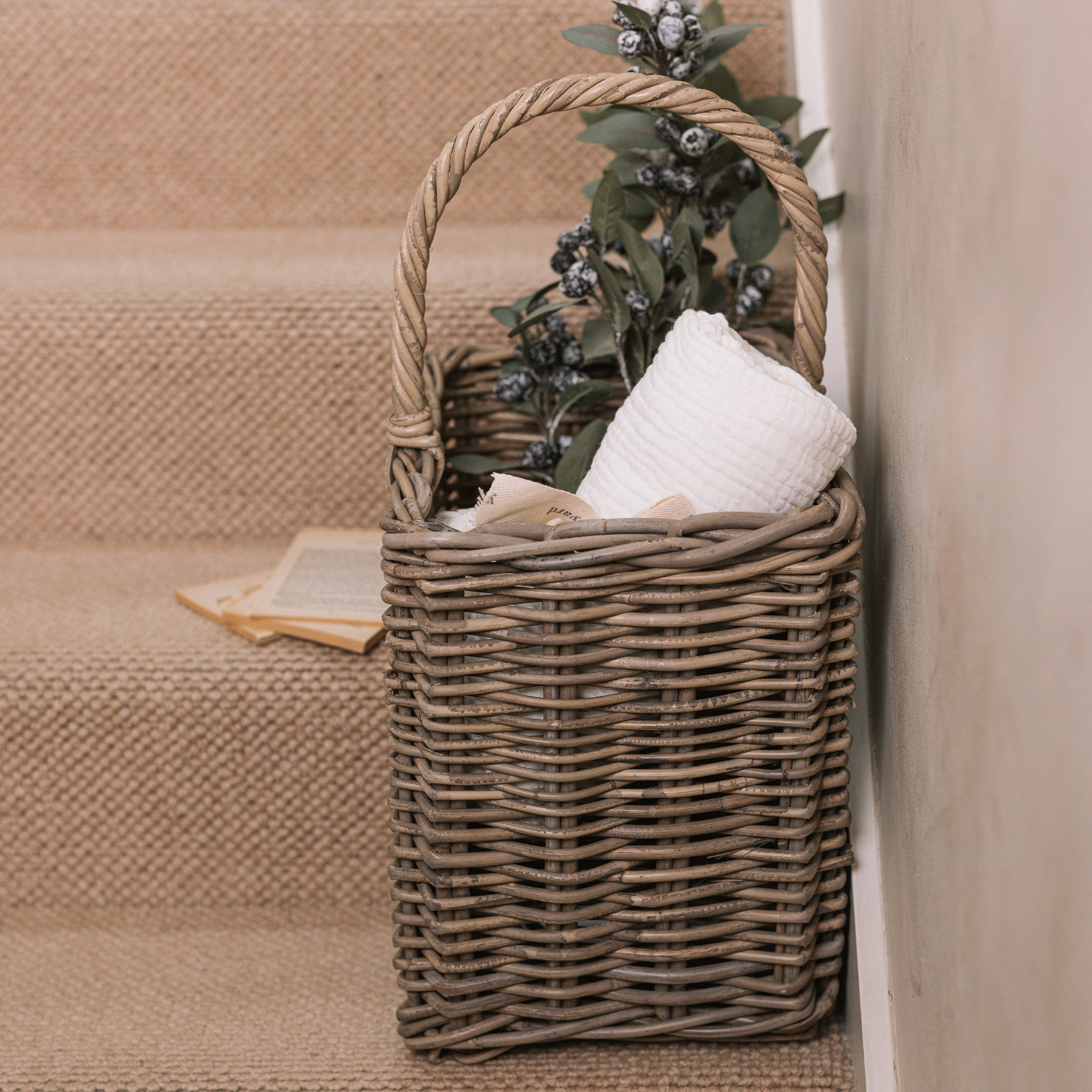 Wicker Stair Basket filled with flowers and a blanket.