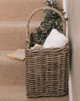 Wicker Stair Basket filled with flowers and a blanket.