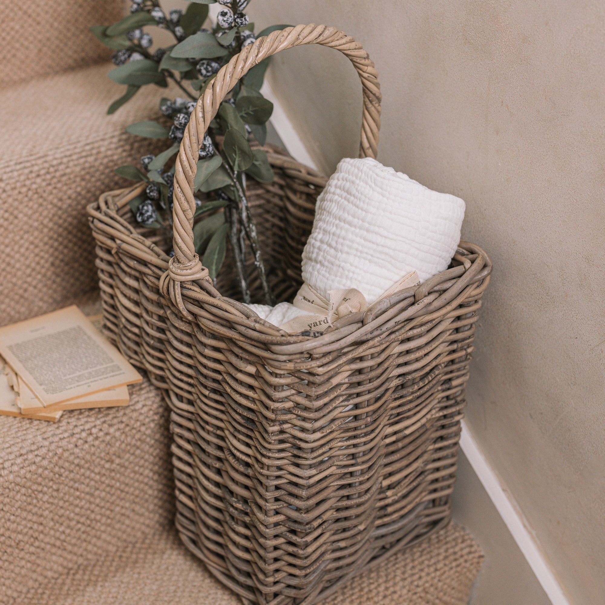 Wicker Stair Basket filled with flowers and a blanket.