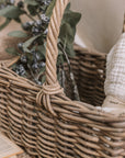 Wicker Stair Basket filled with flowers and a blanket.