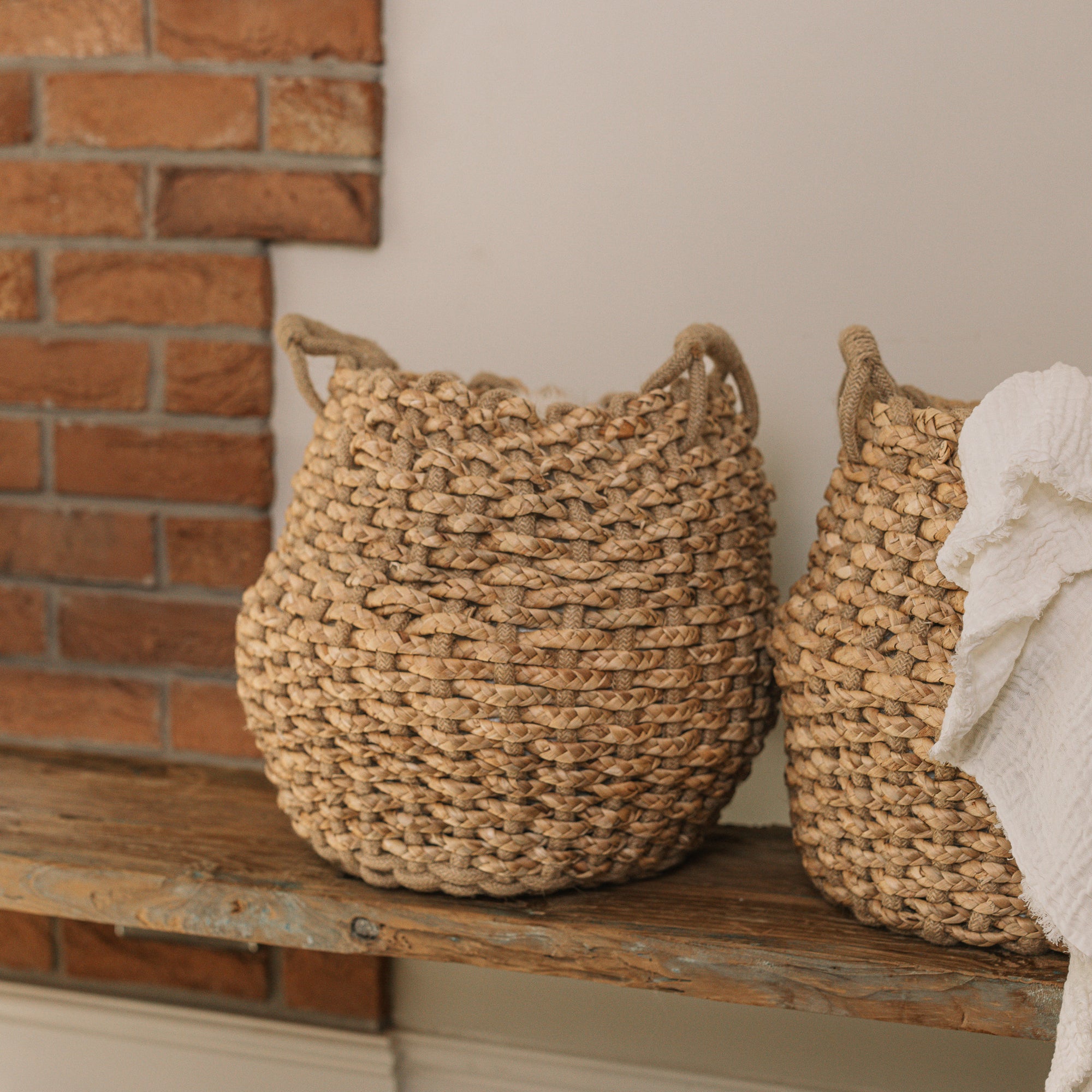 Jute woven basket with handles and a muslin blanket.