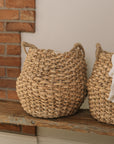 Jute woven basket with handles and a muslin blanket.