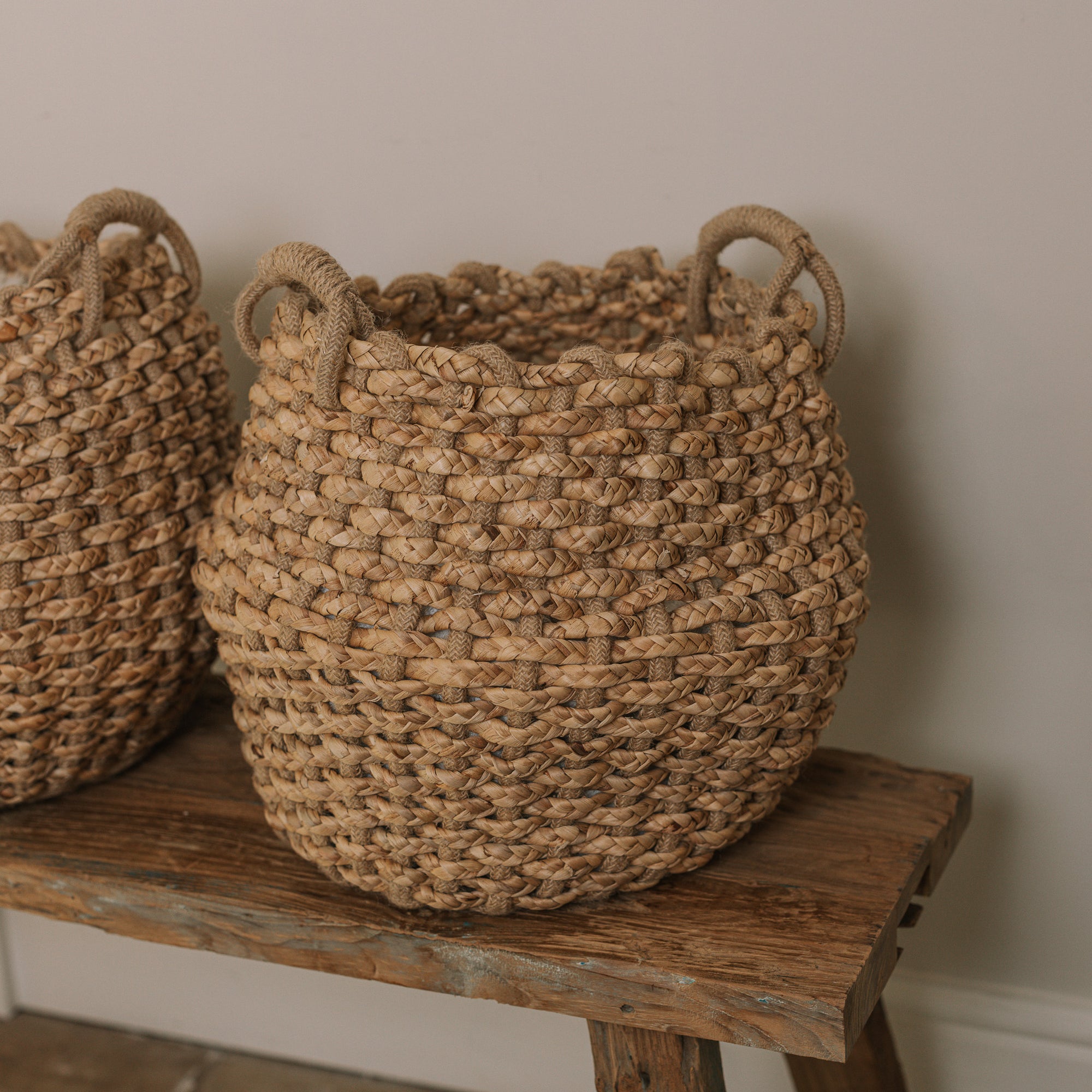 Jute woven basket with handles and a muslin blanket.