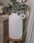 Textured White Vase with berry spray on wooden stool.