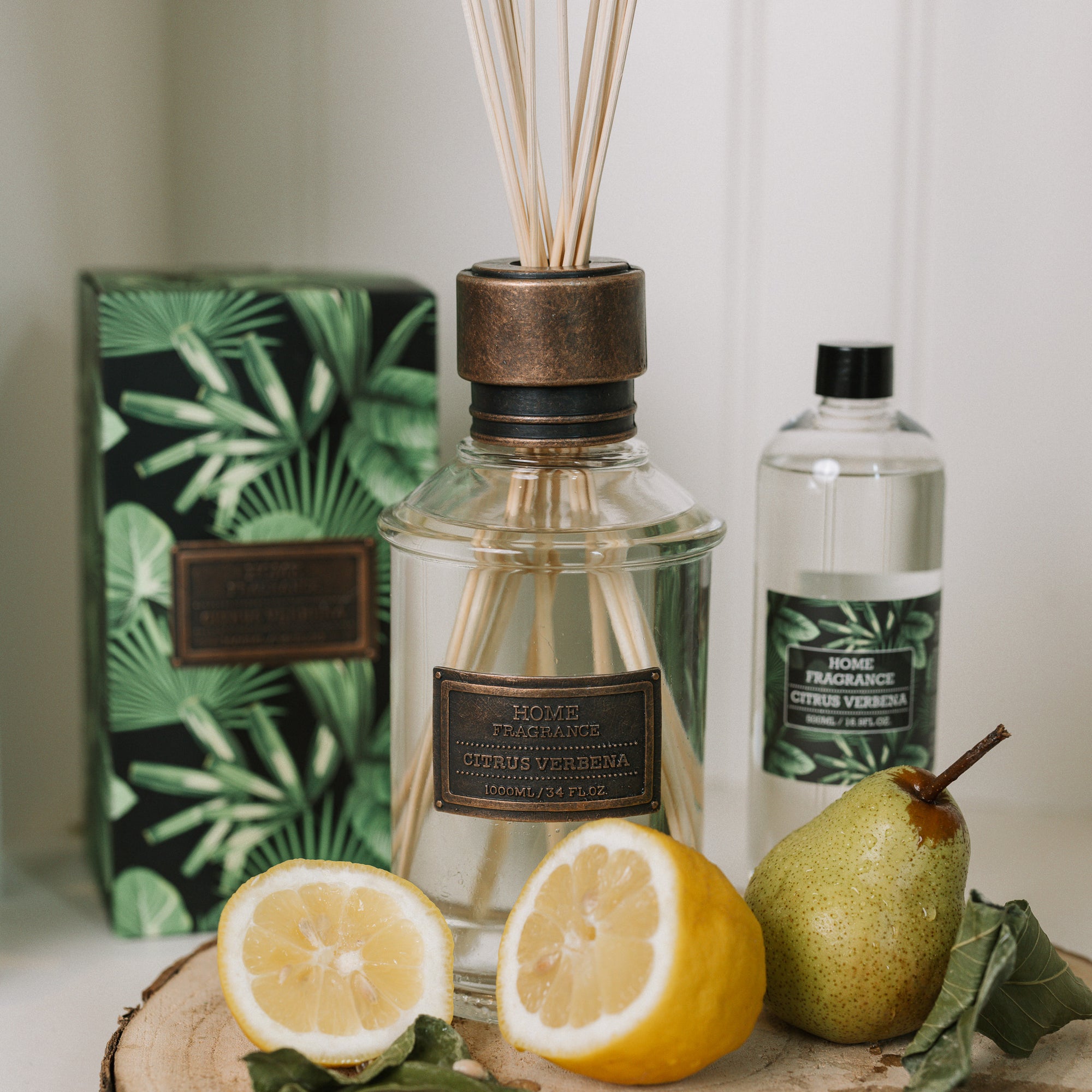 Home fragrance citrus verbena reed diffuser with lemons and greenery.