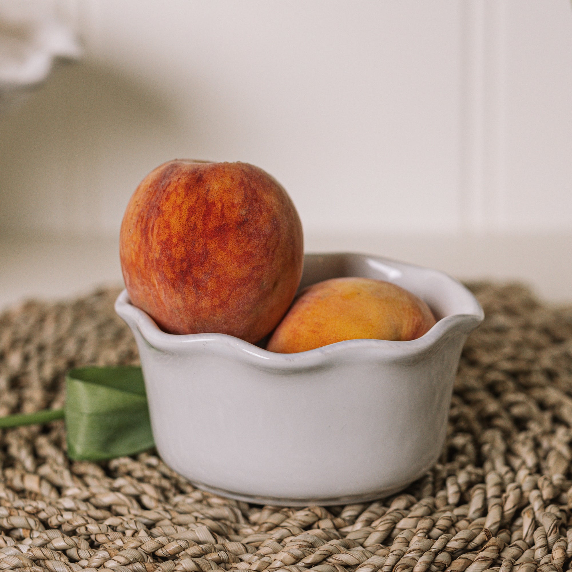 White oval ramekin dish with pie crust top with a pair of peaches.