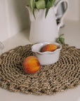 White oval ramekin dish with pie crust top with a pair of peaches.