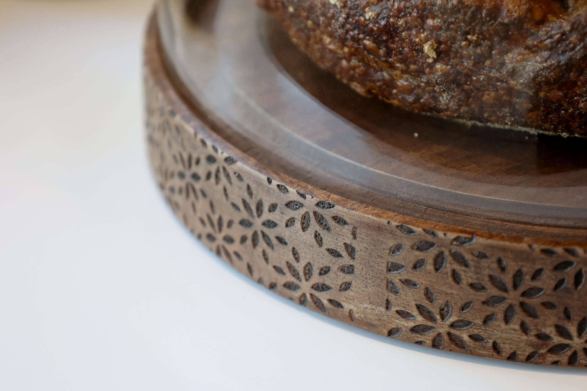 Close up of floral carved detailing on wood and glass dome.