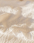 Textured white bedspread in the sunshine.