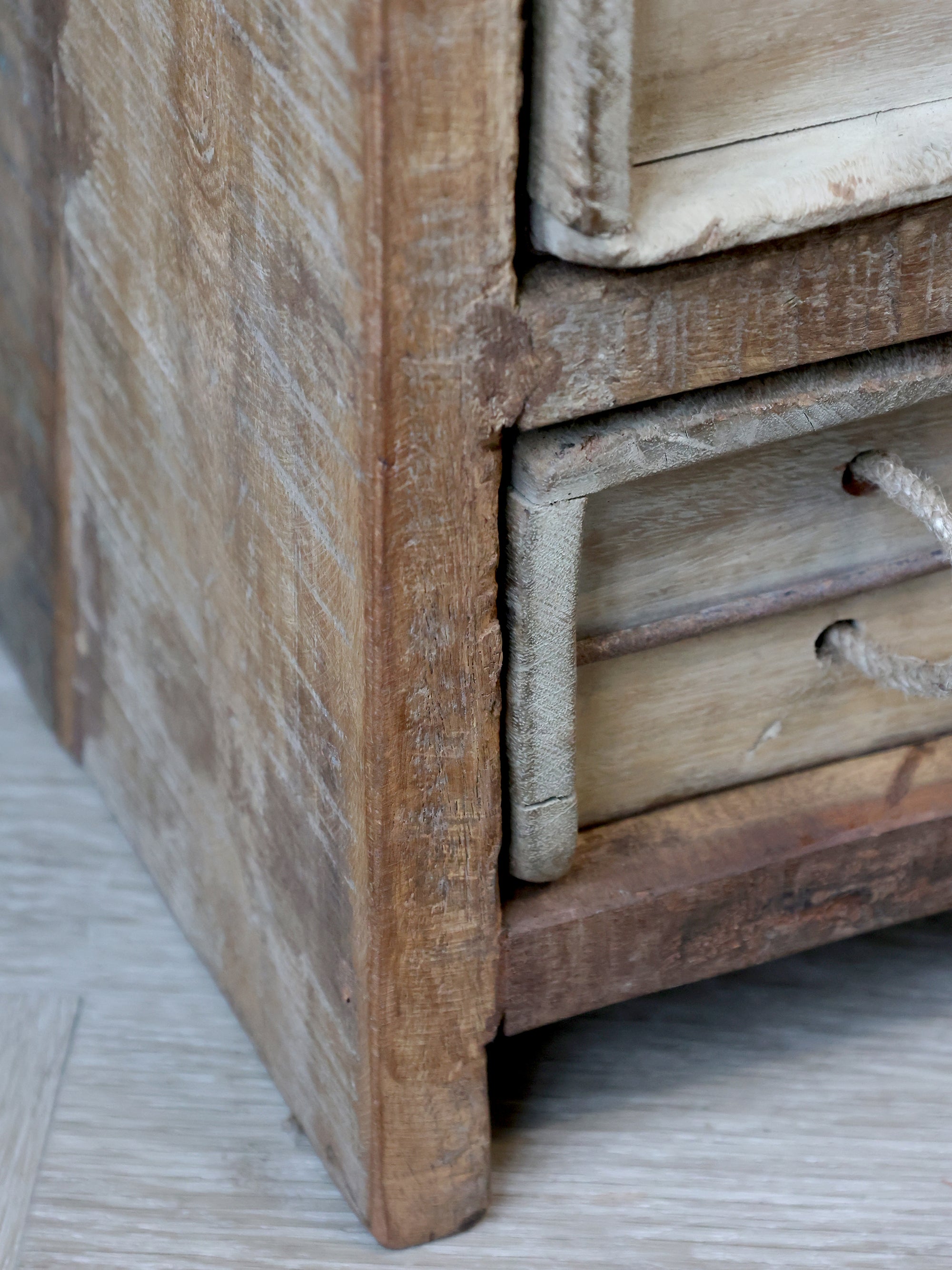 Close up of patina wood on rustic chest of drawers.