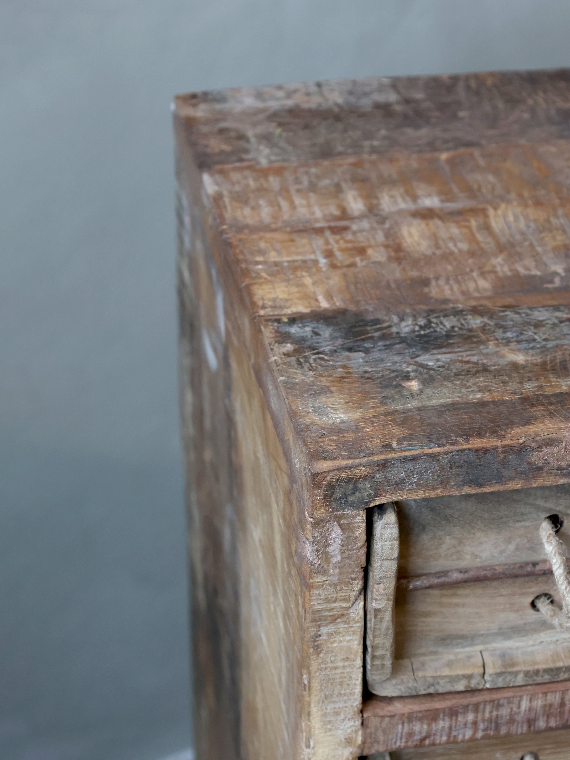 Close up of top surface on rustic chest of drawers.