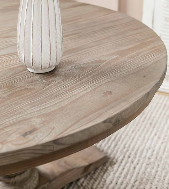 Close up of grain on pine round dining table, with white vase on top.