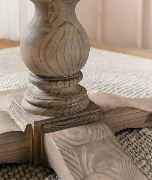 Close up of chunky round leg pillar on round dining table.