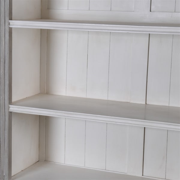 Close up of shelf in white-washed wooden display cabinet.